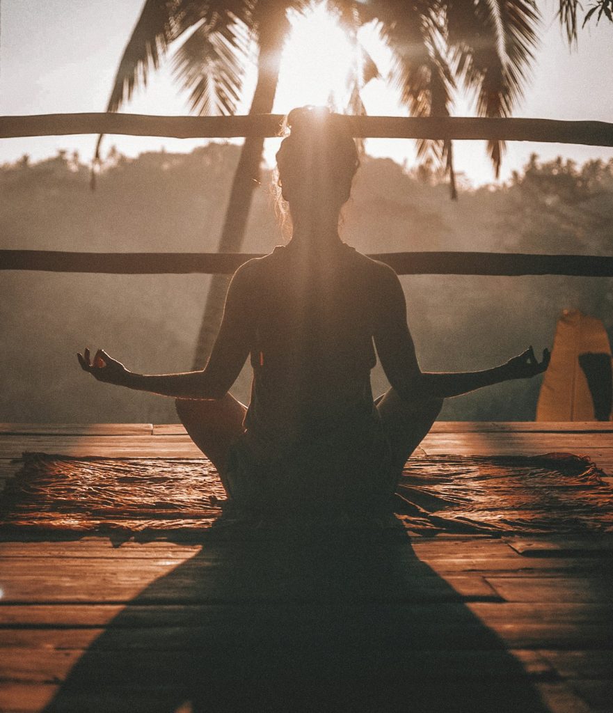 Person meditating at sunset